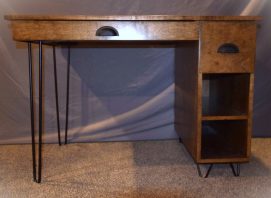 Stained maple with black metal hairpin legs. Storage area in the back for wires.