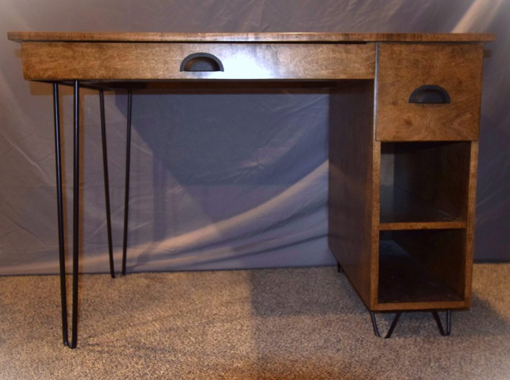 Stained maple with black metal hairpin legs. Storage area in the back for wires.